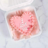 Top view of I Love You Mini Vanilla Cake with pink icing and heart decorations, perfect for gifting on birthdays or special occasions.